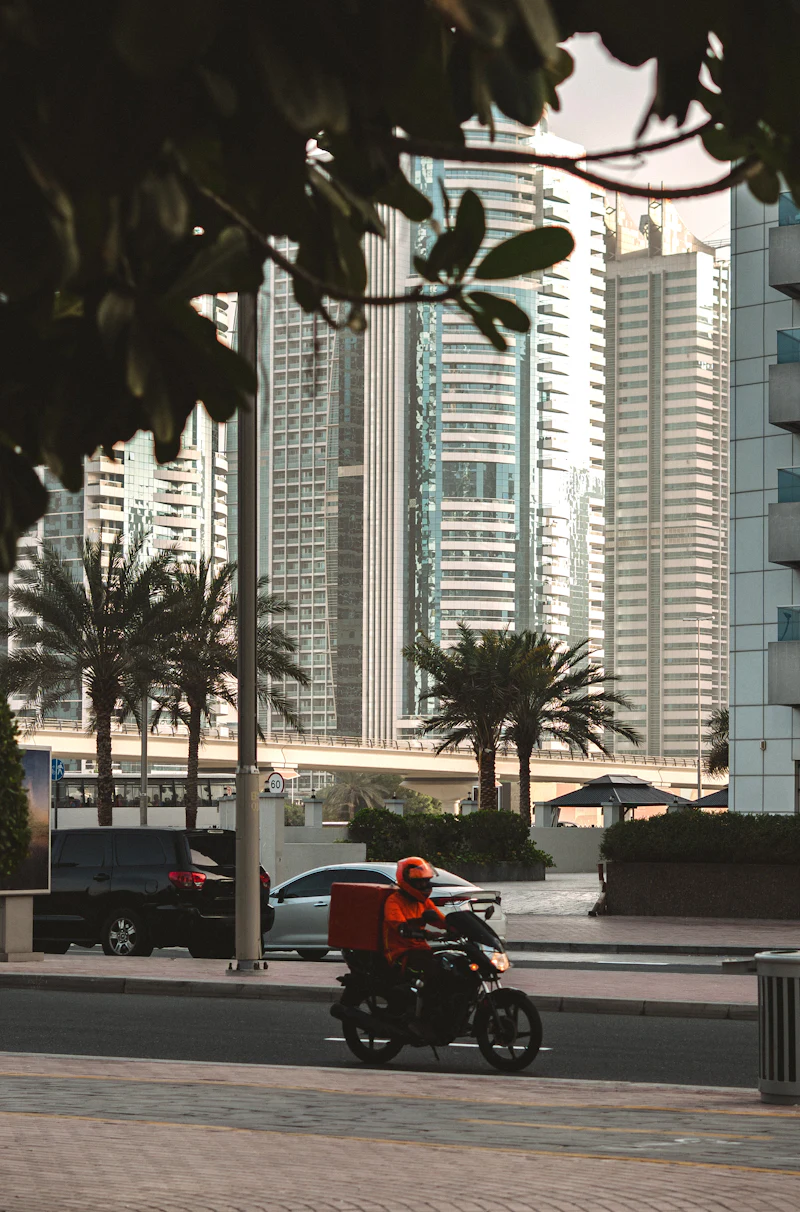 A delivery rider passing through a Dubai street, photographed by Polina Kuzovkova
